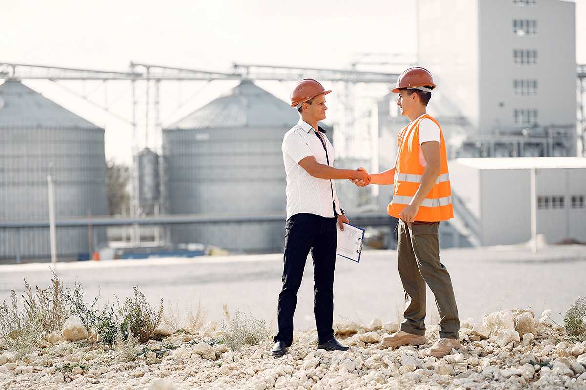 engineers-in-helmets-standing-by-the-factory